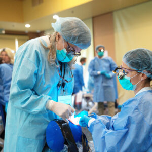 Dental professionals receiving hands-on guidance during a Pinhole Surgical Technique® session.