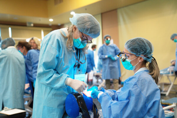 Dental professionals receiving hands-on guidance during a Pinhole Surgical Technique® session.